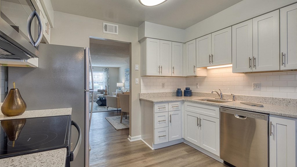 A kitchen with white cabinets and a black stove top.