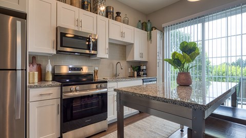 A kitchen with a stove top oven and microwave above it.