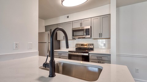 A modern kitchen with a stainless steel sink and appliances.