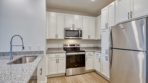 A kitchen with white cabinets and a stainless steel refrigerator.at Allure at Edinburgh, Virginia