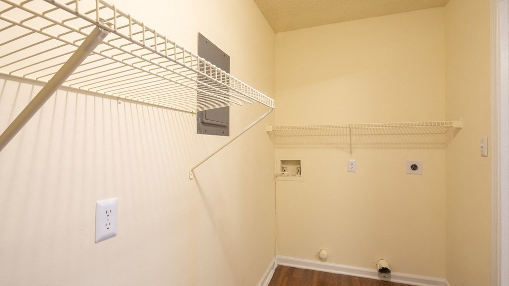 A white wall with a shelf and a light switch.