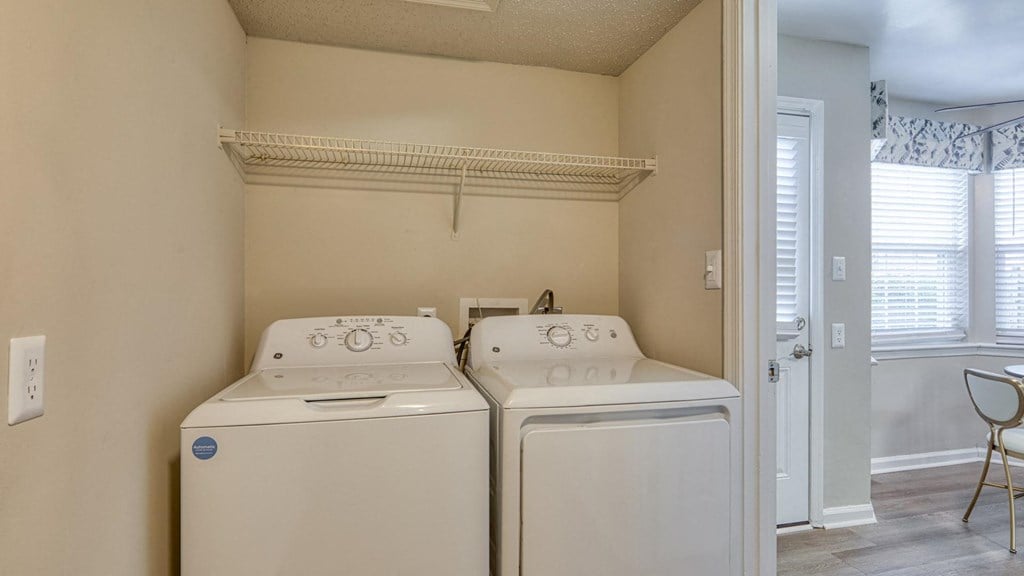 A small laundry room with a washer and dryer.