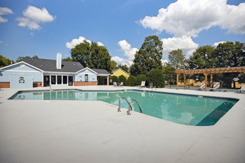 a swimming pool with a house in the background