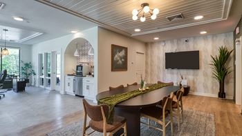 A modern dining room with a large table and chairs.