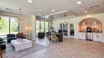A well-lit living room with a kitchen area in the background.