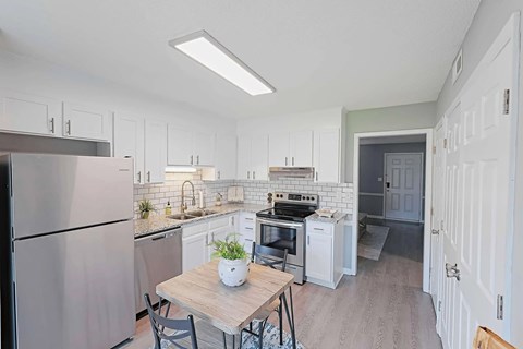 A kitchen with a table and chairs in the middle of it.