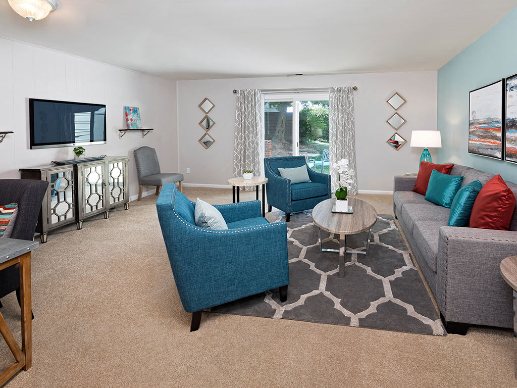 A living room with a blue chair and a grey couch.