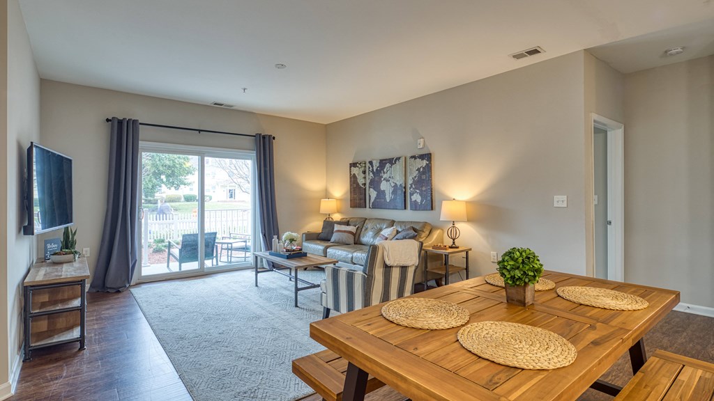 a living room and dining room with a wooden table and a couch