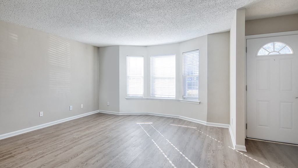 an empty living room with white walls and wood floors