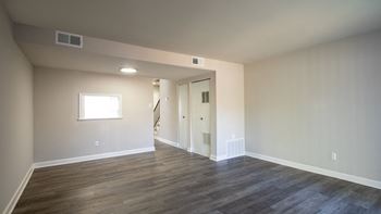 a bedroom with hardwood floors and beige walls