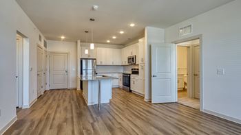 an open kitchen and living room with white walls and wood flooring at The Walker Virginia Center, VA, 23059