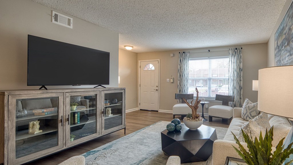 A living room with a television, a couch, and a coffee table.