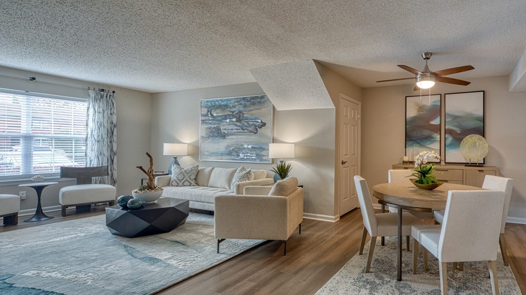 A living room with a couch, chairs, and a table.