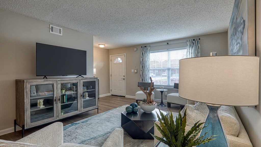 A living room with a television, a glass cabinet, a couch, and a coffee table.