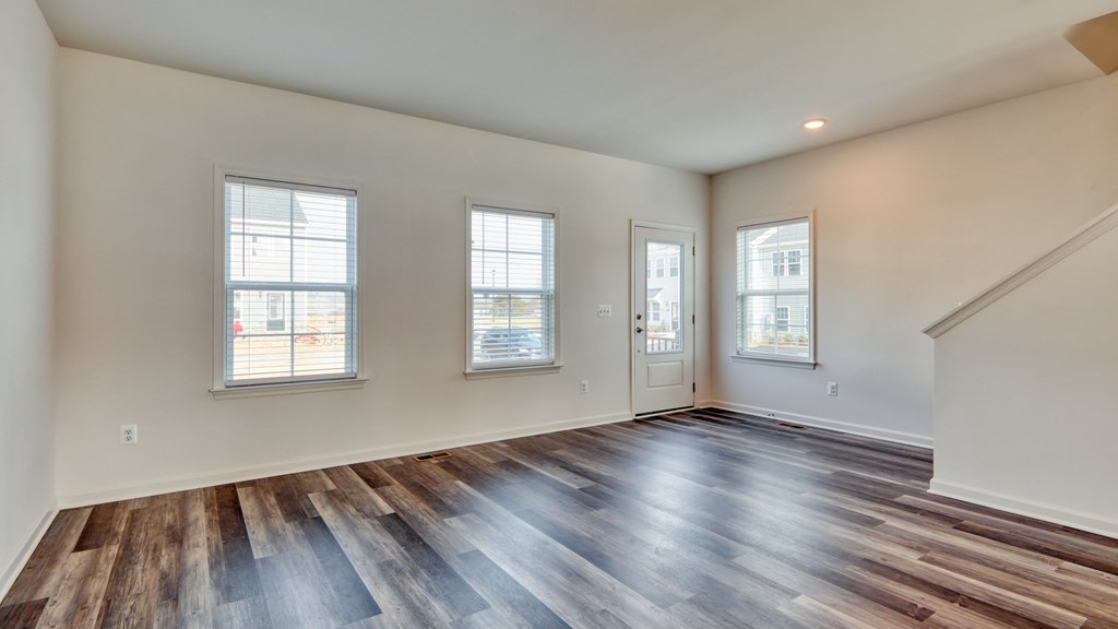 Living room with a large window and a wooden floor at The Mark Townhomes Apartments, Harrisonburg, VA, 22801