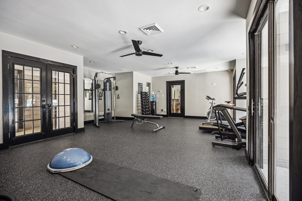 a home gym with exercise equipment and a surfboard