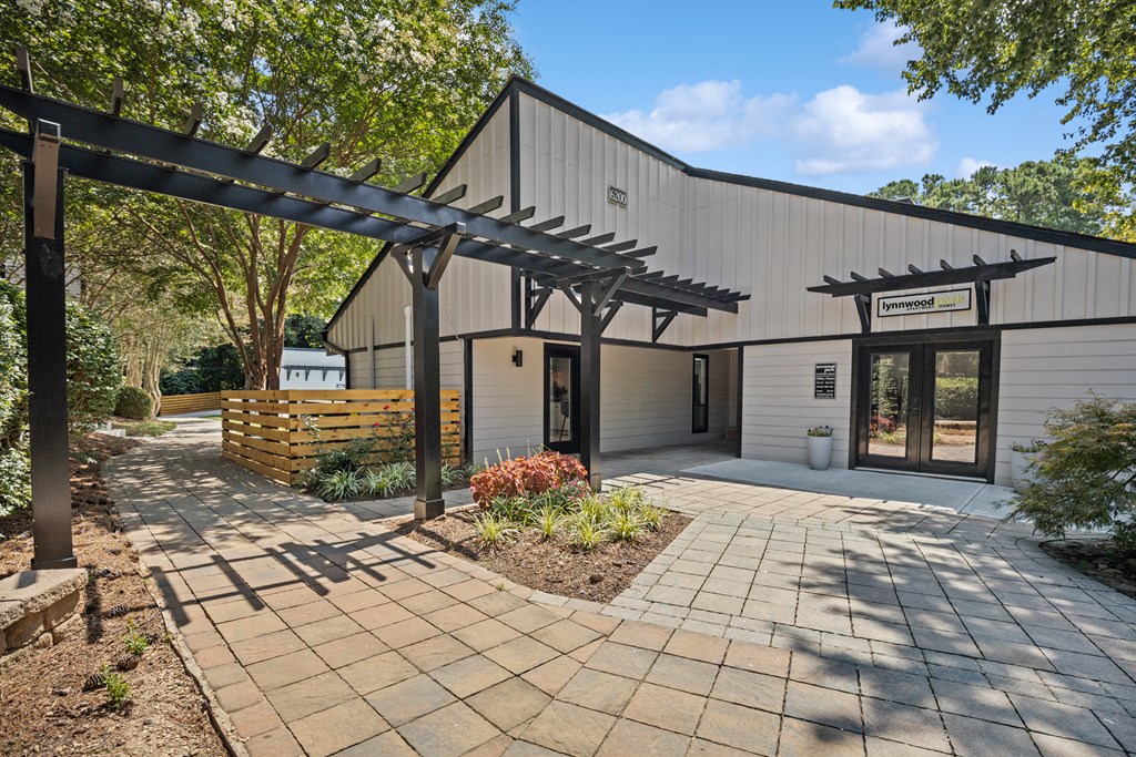 a building with awnings and a brick walkway with trees in the background