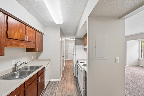 A kitchen with wooden cabinets and a white sink.