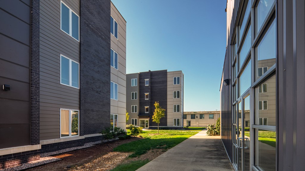 a pathway between two apartment buildings on a sunny day