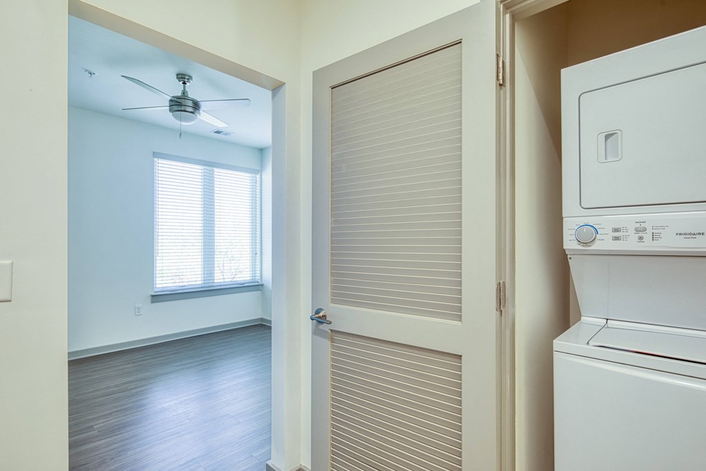 a laundry room with a washer and dryer and a closet with a door
