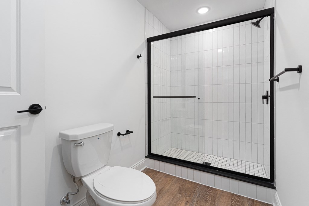 a white bathroom with a shower and a toilet at The Madison, Columbus, Ohio