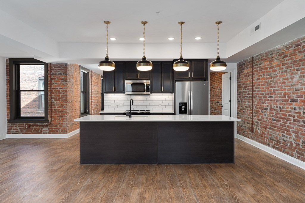 a kitchen with a large island and a brick wall at The Madison, Ohio, 43215