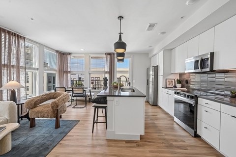 A modern kitchen with white cabinets and a black stove top.