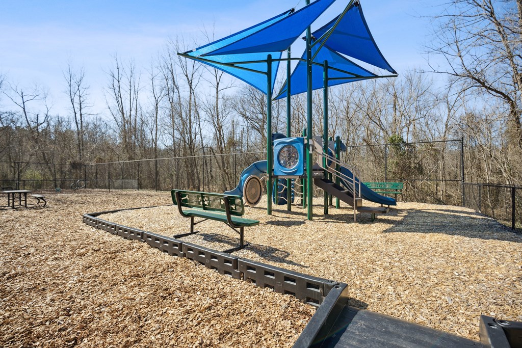 a playground with a blue structure and benches