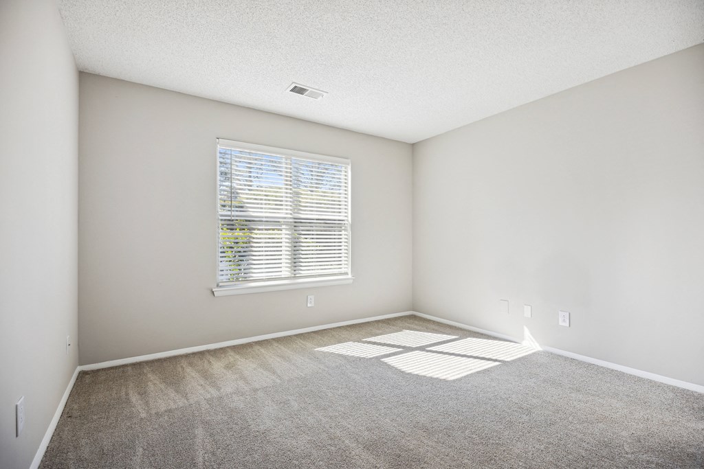 an empty room with carpet and a window