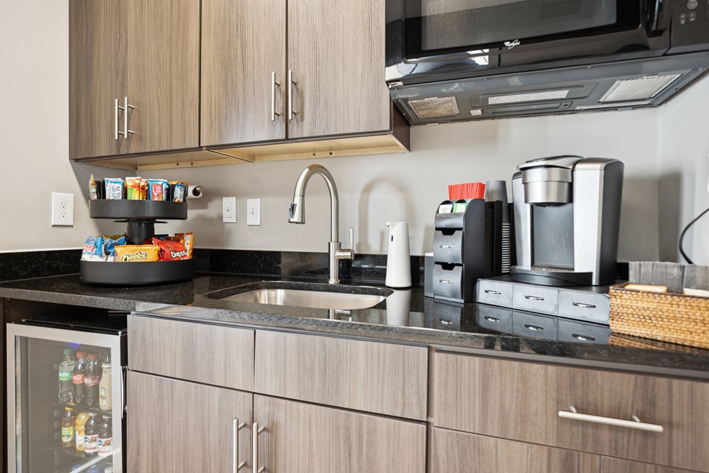 a kitchen with a sink and a coffee maker on the counter