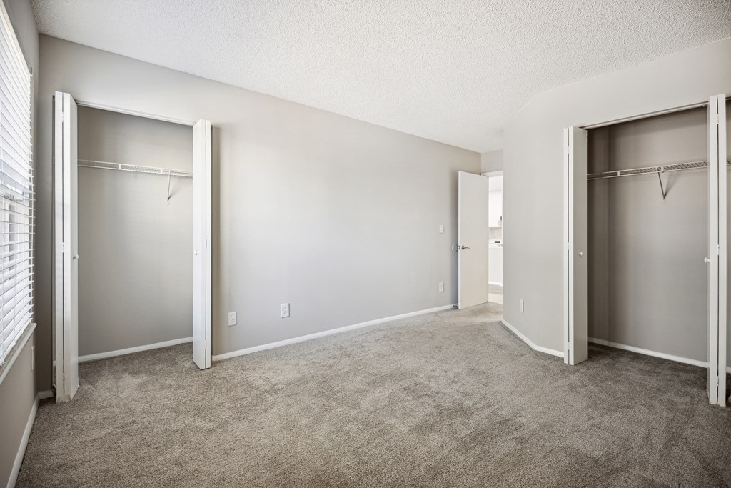 an empty room with two closets and a carpeted floor