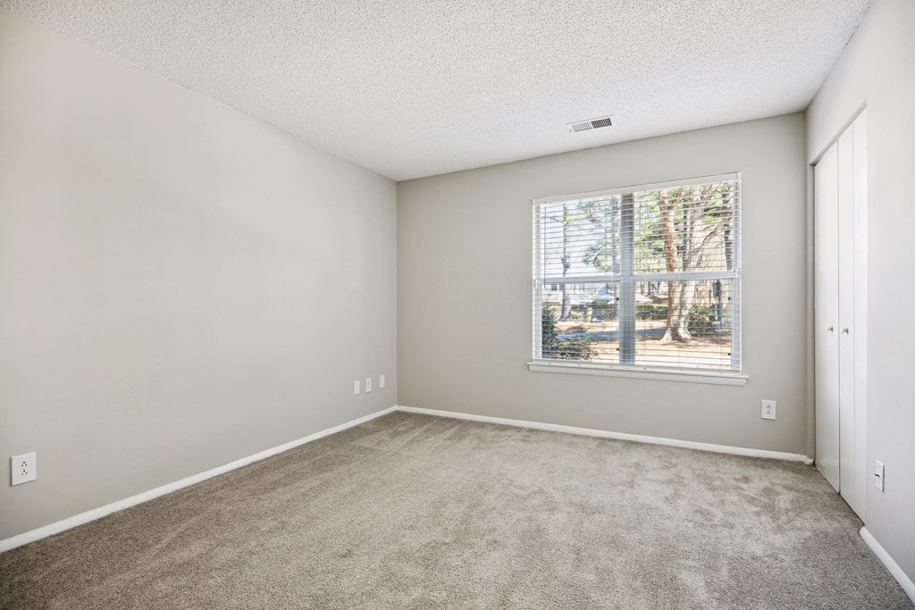 an empty room with carpet and a window
