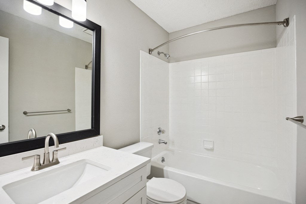 a white bathroom with a white sink and a tub and a white toilet