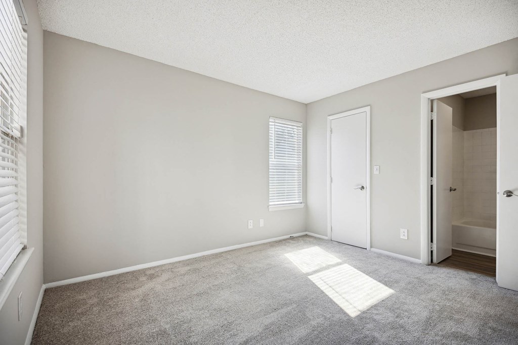 an empty living room with a door to a bathroom