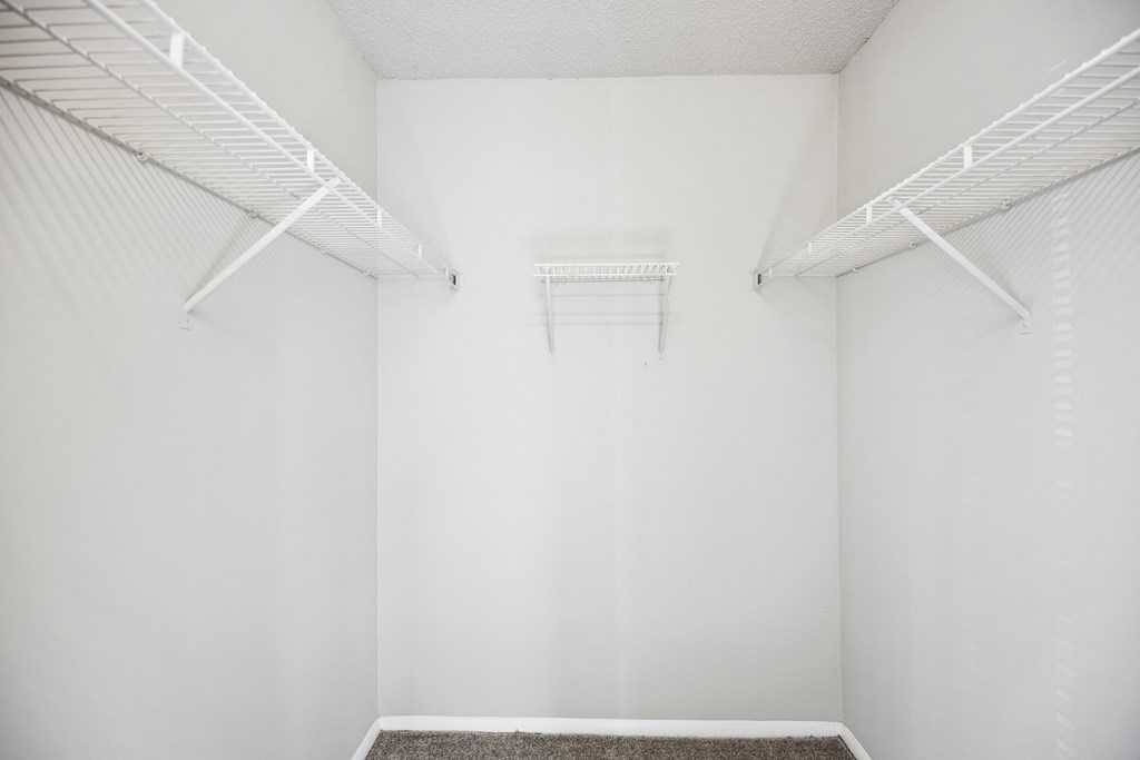 an empty room with white walls and white racks on the wall