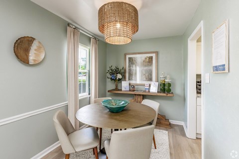 A dining room with a round table and chairs.