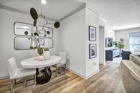 A modern dining room with a white table and chairs.