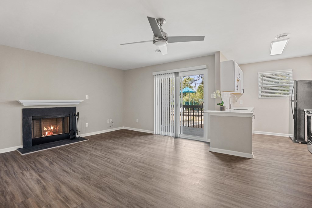 a living room with a fireplace and a door to a balcony
