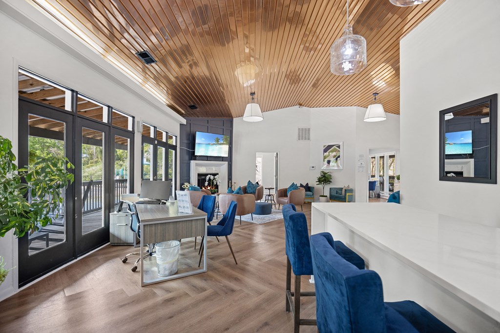 a living room with blue chairs and a bar and a fireplace