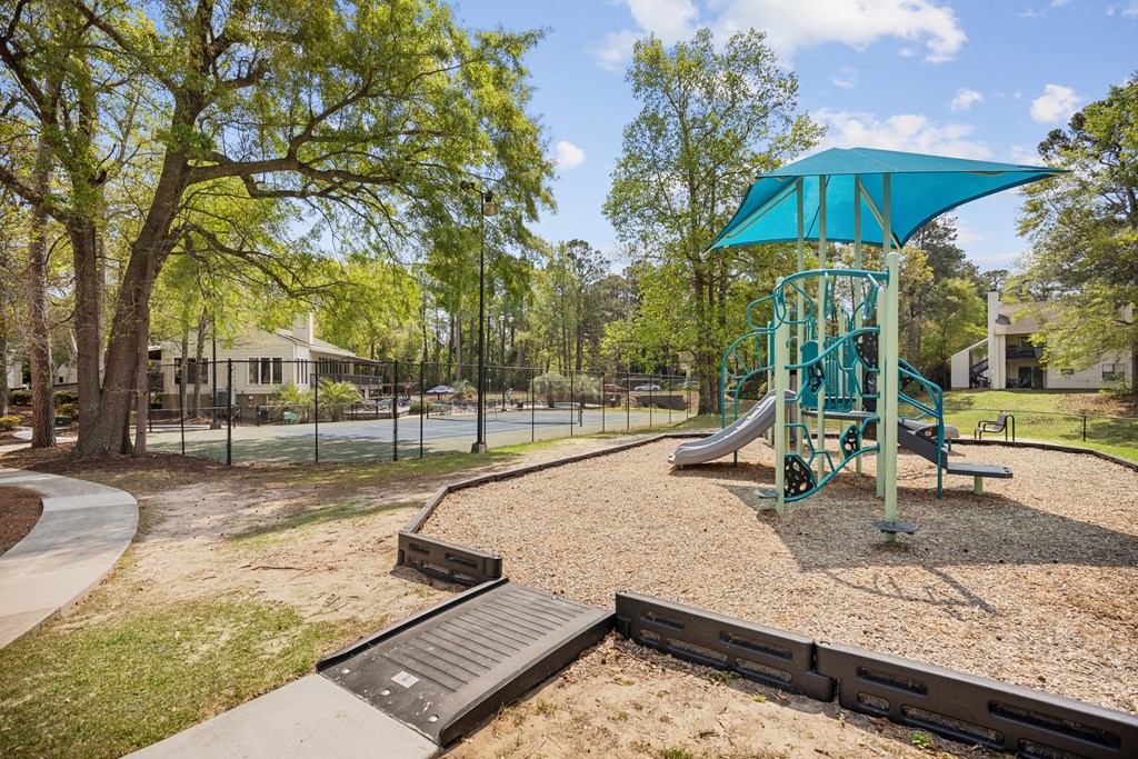 a playground with a swing set and a slide in a park
