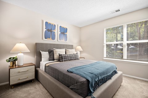 a bedroom with a bed and two windows