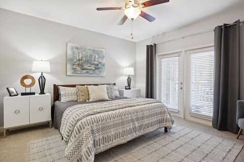 A bedroom with a large bed and a ceiling fan.