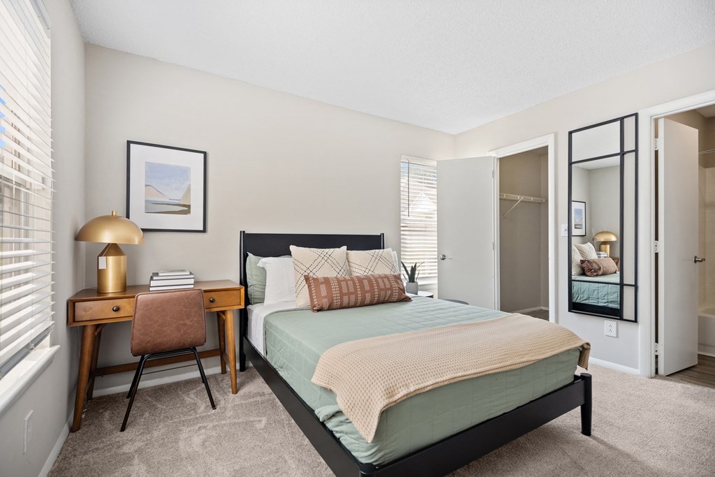 a bedroom with a bed and a desk and a closet