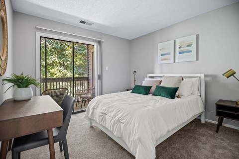 a bedroom with a bed and a door to a balcony