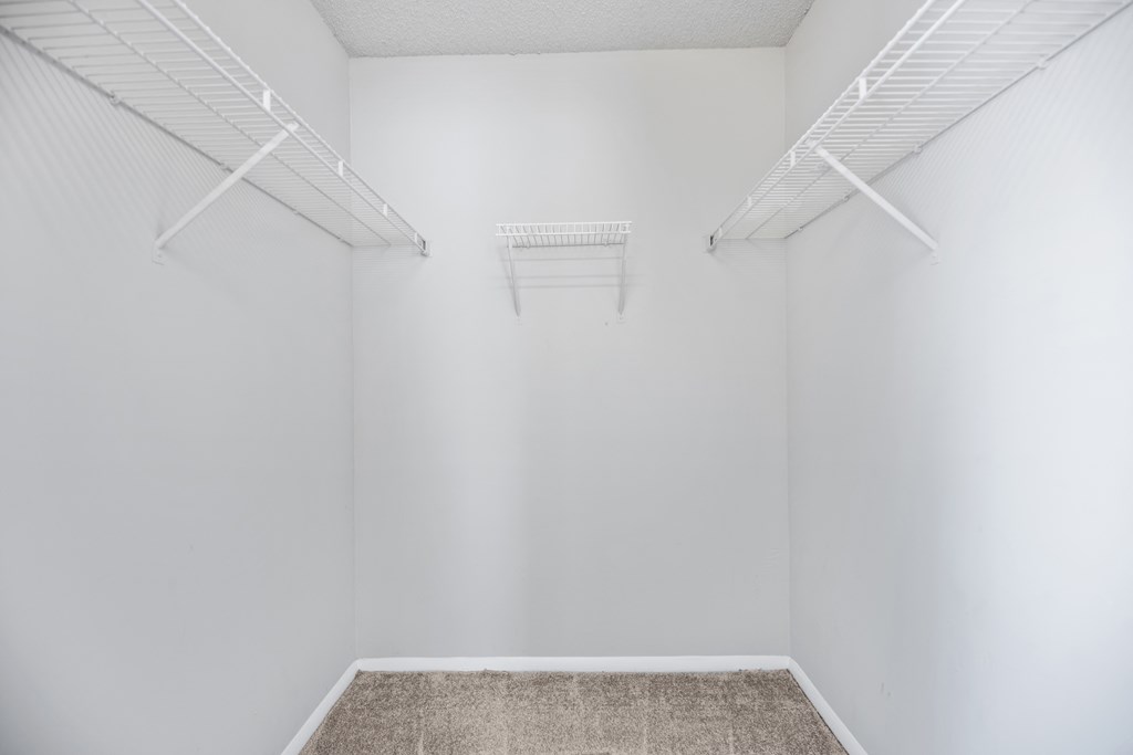 an empty room with white walls and two white shelves on the wall