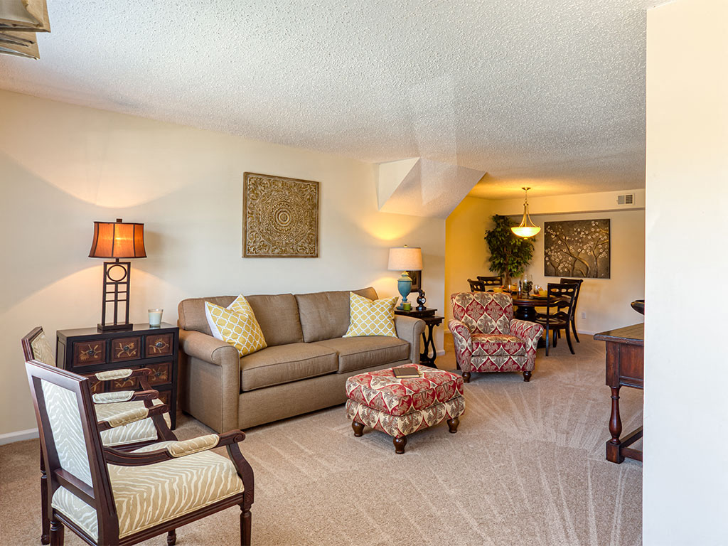 a living room and dining room with a couch and chairs