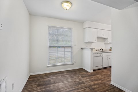 A room with a window and a kitchenette.
