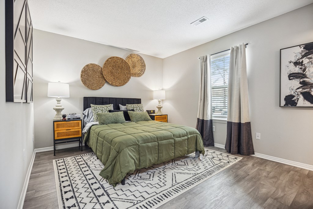 a bedroom with a green bed and a rug