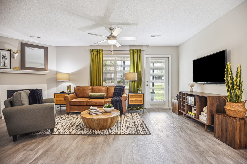 a living room with a ceiling fan and a tv
