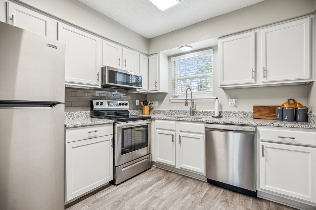 a kitchen with white cabinets and stainless steel appliances